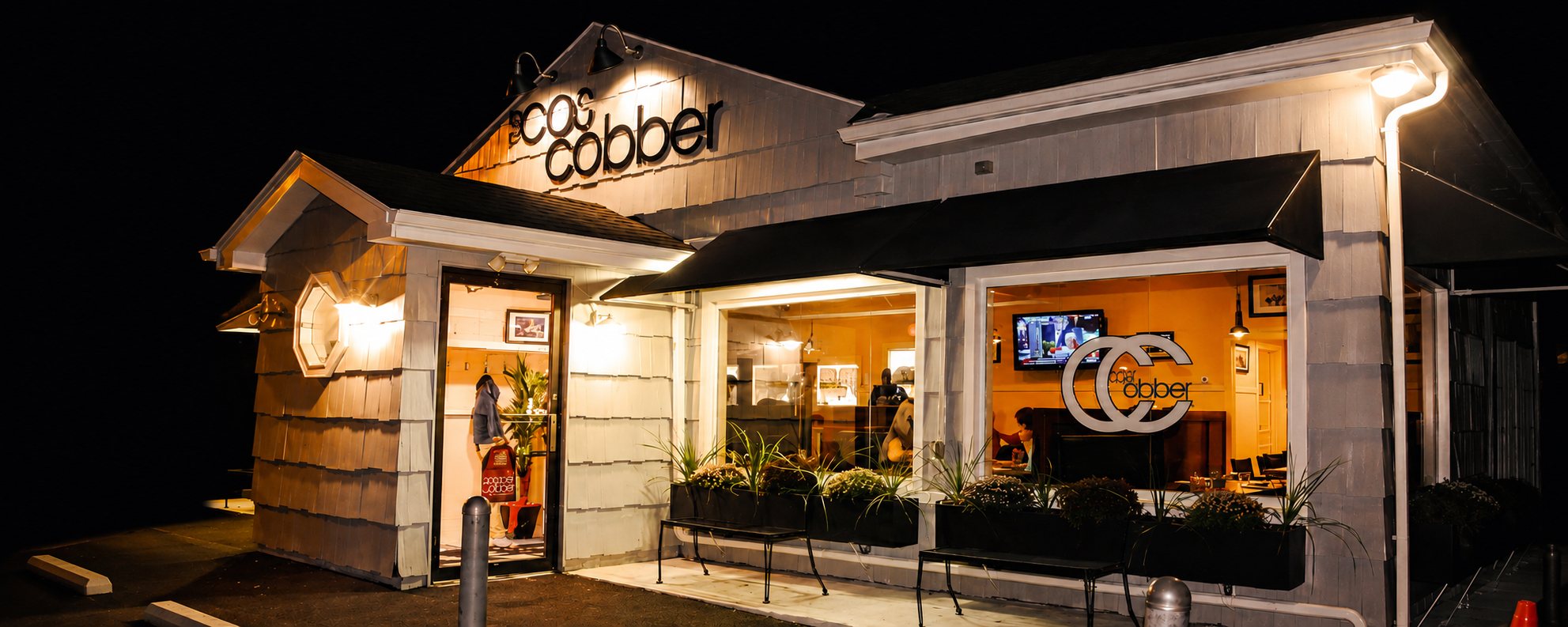 Caren's Cos Cobber storefront lit up at night