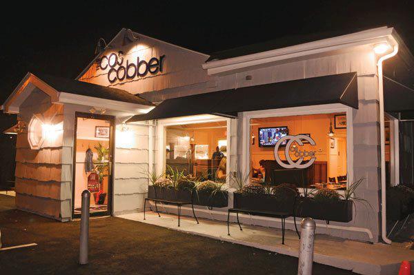 Caren's Cos Cobber storefront lit up at night